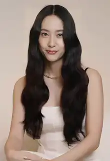 Jung in peach-colored dress posing the camera