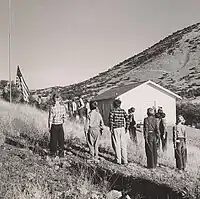 Students of the Little Outfit Schoolhouse raising the US flag in 1943