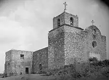 A large stone complex, several stories high.  Two crosses top the structures in the foreground.