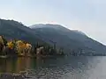 A lake as it encounters foothills covered in trees