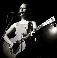 Veirs singing and playing acoustic guitar onstage