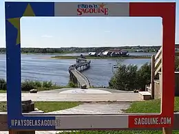 A footbridge leading to an island with a group of buildings