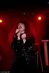 A woman sings into the microphone.