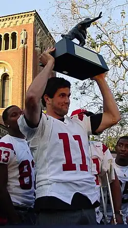 A picture of Matt Leinart holding his Heisman trophy.