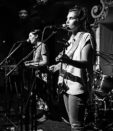 The band onstage in front of microphones