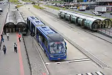 Blue articulated bus at a station