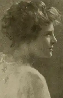 A young white woman with fair hair in a bouffant updo, photographed in profile