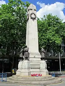 A tall stone obelisk in front of a building