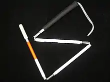 White cane with red band, folded into four segments