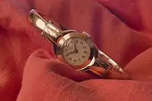 Metal watch on piece of cloth