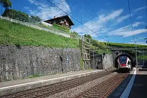 Red-and-white train exits tunnel