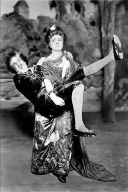 White woman in Victorian "aesthetic" costume carrying off a white man, who looks comically terrified