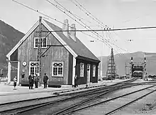 A small wooden train station building with a railway ferry in the background