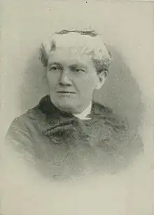 B&W portrait photo of a white-hair old woman wearing a dark, collared jacket.