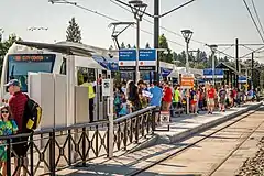 A MAX train stopped at the crowded platform of Milwaukie/Main Street station