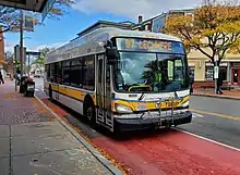 A bus on a red bus lane in an urban square