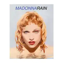 A close-up image of Madonna submerged with her head above water and her hands over her breasts.