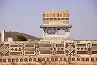 Low rectangular tomb carved and painted with geometric shapes