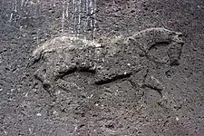 Large low-relief depiction on the interior side of the stone lintel above the entry.