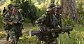 A Malaysian Army operative (left) holding the M16A1 carbine.