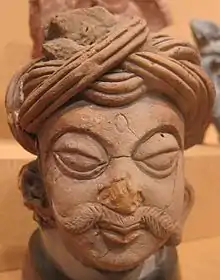 Terracotta head, wearing possibly an early form of pagri from the Gupta period.