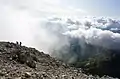 Hikers approaching the top of Mangart; view toward the southwest