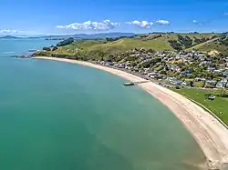 Aerial overview of Maraetai beach, showing township and pier