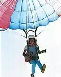 Masayoshi Takanaka parachuting with one of his guitars