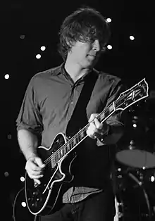 Matthew Caws onstage with guitar, facing left of camera