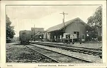 A black-and-white postcard of a small wooden railway station