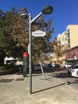 Street sign pole with lamps on pavement