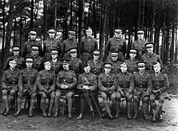 Formal photograph of a group of officer cadets and instructors