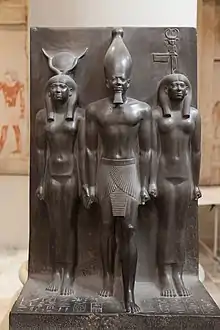 Goddess representation in Egyptian monuments: in this triad the Egyptian goddess Hathor (left) and the nome goddess Bat (right) lead Pharaoh Menkaura (middle). Egypt, Fourth dynasty, about 2400 BCE. Graywacke. Cairo Museum.