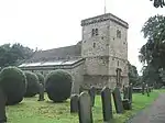 Church of St Michael and grave cover leaning on buttress beside north door