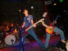 Several men performing onstage playing instruments