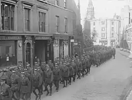 Photograph of a column of officer cadets marching down a Cambridge street