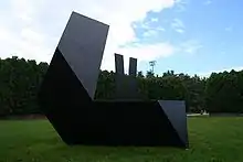 A geometric iron sculpture in a park outdoors