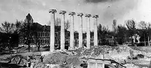 The Columns stand in the rubble of Academic Hall after the 1892 fire, the new buildings of Francis Quad in the background