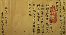 Texts in Chinese letters on brownish aged paper. A red handprint is placed over the text.