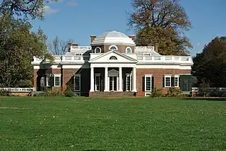 Red brick building with a white classicist columned entrance.