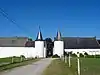 De torens, het hoofdgebouw en de stallen van het kasteelboerderij van Montignies-Saint-Christophe