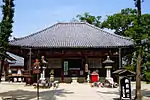 Small wooden building with a trapezoidal roof.