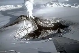 A snow-covered mountain with a plume of steam rising from the top