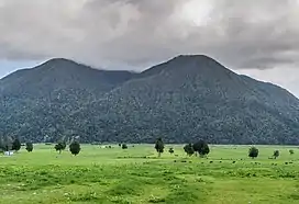 Image of a cloudy Mount Te Kinga with farmland in front