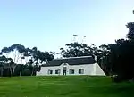 Rectangular building in the vernacular style, hipped, thatched roof, eyebrow gable over front door.
Outbuildings to rear This oblong house, with its predominantly Cape Dutch features, dates from approximately 1840.
Type of site: House
Previous use: Residential.
Current use: House.