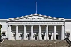 A white building with a triangular façade and wide stairs