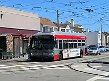 A bus on a street with overhead wires