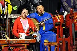 A woman playing the đàn bầu.