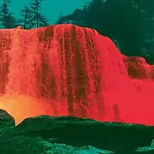 A color-inverted photograph of a waterfall