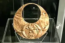 "Crescentic bronze plaque" in the shape of a gold lunula, with triskele-like decoration